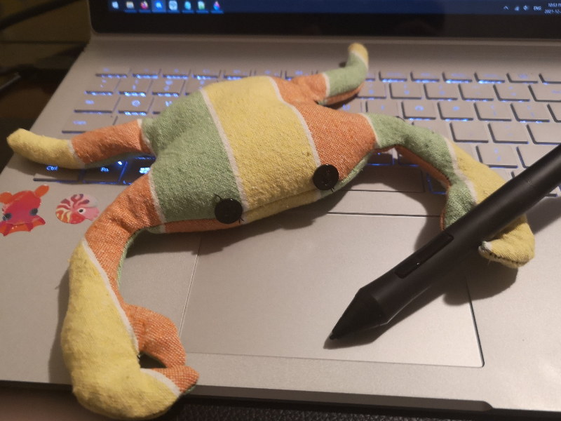 the crab bag, posed in front of a laptop with a tablet pen in one claw